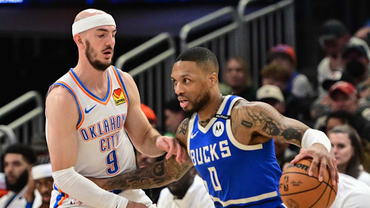 Mar 16, 2025; Milwaukee, Wisconsin, USA; Milwaukee Bucks guard Damian Lillard (0) drives past Oklahoma City Thunder guard Alex Caruso (9) in the second quarter at Fiserv Forum. Mandatory Credit: Benny Sieu-Imagn Images Mar 16, 2025; Milwaukee, Wisconsin, USA; Milwaukee Bucks guard Damian Lillard (0) drives past Oklahoma City Thunder guard Alex Caruso (9) in the second quarter at Fiserv Forum. Mandatory Credit: Benny Sieu-Imagn Images