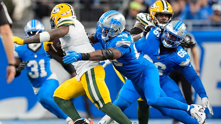 Detroit Lions linebacker Al-Quadin Muhammad (69) tackles Green Bay Packers running back Josh Jacobs (8) during the second half at Ford Field in Detroit on Thursday, Dec. 5, 2024.