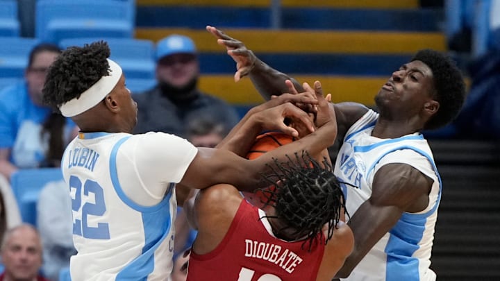 Dec 4, 2024; Chapel Hill, North Carolina, USA; Alabama Crimson Tide forward Mouhamed Dioubate (10) fights for the ball with North Carolina Tar Heels forward Ven-Allen Lubin (22) and guard Drake Powell (9) in the second half at Dean E. Smith Center. Mandatory Credit: Bob Donnan-Imagn Images