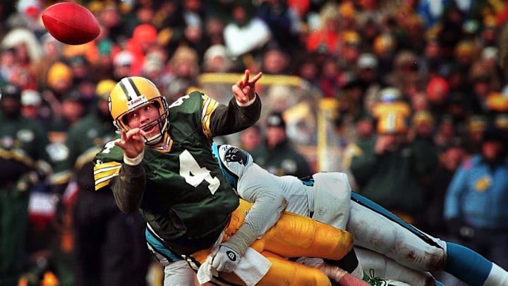 Green Bay Packers quarterback Brett Favre releases a shuttle pass to Dorsey Levens for a first down while in the grasp of Carolina Panthers linebacker Kevin Green during the third quarter of the 1997 NFC Championship game Sunday, January 12, 1997 at Lambeau Field in Green Bay, Wis.(Milwaukee Journal Sentinel photo by Dale Guldan)