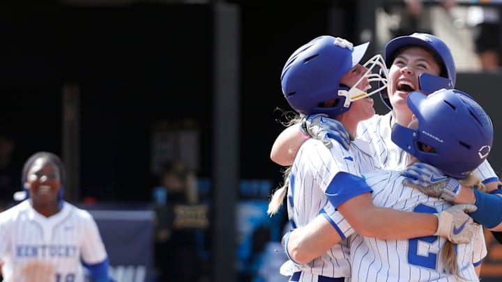 Kentucky's Ally Hutchins (7), facing camera, celebrates with Erin Coffel (21) and Grace Lorsung (33) after driving in the game-winning run in the seventh inning of a softball game against Michigan in the first round of the Stillwater Regional of the NCAA Tournament in Stillwater, Okla., Friday, May 17, 2024.