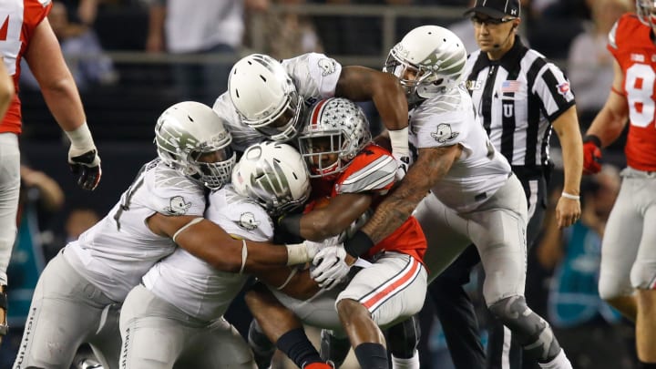 Jan 12, 2015; Arlington, TX, USA; Ohio State Buckeyes running back Curtis Samuel (4) is gang tackled by the Oregon Ducks defense in the 2015 CFP National Championship Game at AT&T Stadium. Ohio State won 42-20. Mandatory Credit: Tim Heitman-USA TODAY Sports