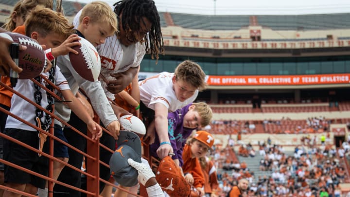 April 20, 2024; Austin, Texas, USA: Texas Orange team defensive back Terrance Brooks (8) signs autographs for fans while visiting for the Longhorns' spring Orange and White game at Darrell K Royal Texas Memorial Stadium. Mandatory Credit: Sara Diggins-USA Today Sports via American Statesman
