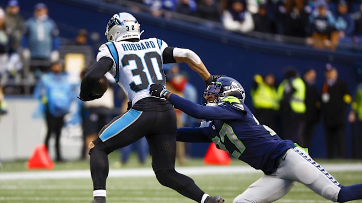 Dec 11, 2022; Seattle, Washington, USA; Carolina Panthers running back Chuba Hubbard (30) stiff arms a way from a tackle attempt by Seattle Seahawks cornerback Tariq Woolen (27) during the fourth quarter at Lumen Field. Dec 11, 2022; Seattle, Washington, USA; Carolina Panthers running back Chuba Hubbard (30) stiff arms a way from a tackle attempt by Seattle Seahawks cornerback Tariq Woolen (27) during the fourth quarter at Lumen Field.