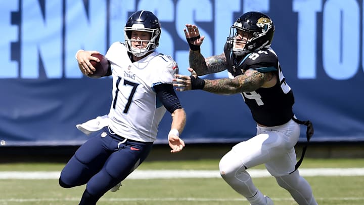 Tennessee Titans quarterback Ryan Tannehill scrambles up the field away from Jacksonville Jaguars defensive end Cassius Marsh.