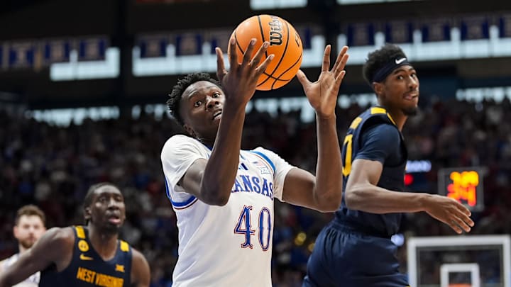 Dec 31, 2024; Lawrence, Kansas, USA; Kansas Jayhawks forward Flory Bidunga (40) grabs a loose ball against West Virginia Mountaineers guard Sencire Harris (10) and center Eduardo Andre (0) during the second half at Allen Fieldhouse. Mandatory Credit: Jay Biggerstaff-Imagn Images