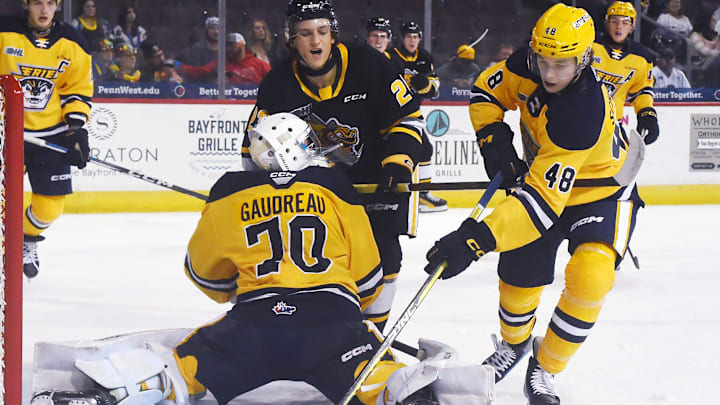 Erie Otters defenseman Matthew Schaefer, right, clears the puck behind teammate Ben Gaudreau against the Sarnia Sting at Erie Insurance Arena in Erie on Oct. 21, 2023.
