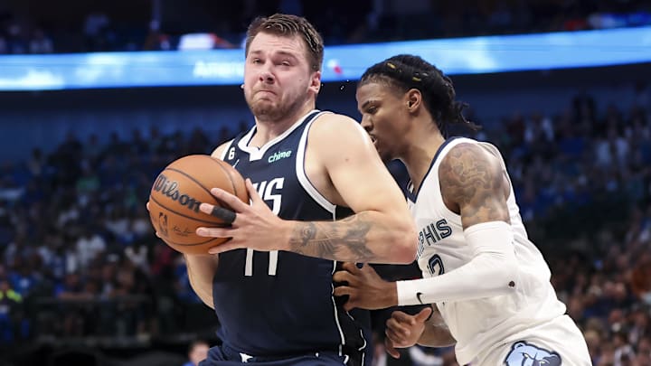 Dallas Mavericks guard Luka Doncic (77) controls the ball as Memphis Grizzlies guard Ja Morant (12) defends during the first quarter at American Airlines Center. Mandatory Credit: Kevin Jairaj-Imagn Images