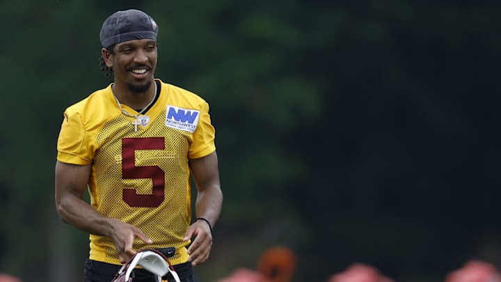 Washington Commanders quarterback Jayden Daniels smiles on the field.