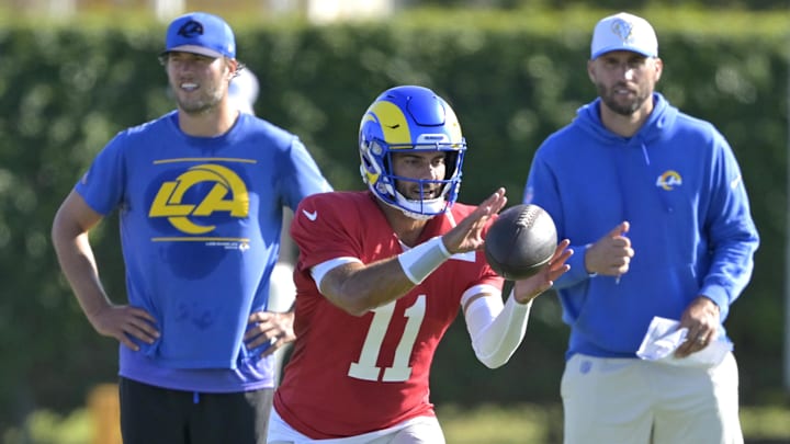 Jul 29, 2024; Los Angeles, CA, USA; Los Angeles Rams quarterback Matthew Stafford (9) and quarterbacks coach Dave Ragone look on as quarterback Jimmy Garoppolo (11) participates in drills during training camp at Loyola Marymount University. Mandatory Credit: Jayne Kamin-Oncea-Imagn Images Jul 29, 2024; Los Angeles, CA, USA; Los Angeles Rams quarterback Matthew Stafford (9) and quarterbacks coach Dave Ragone look on as quarterback Jimmy Garoppolo (11) participates in drills during training camp at Loyola Marymount University. Mandatory Credit: Jayne Kamin-Oncea-Imagn Images
