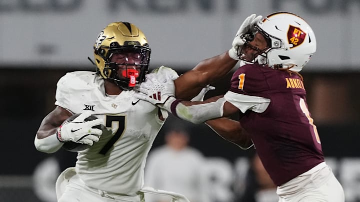 UCF Knights running back RJ Harvey (7) delivers a stiff arm to Arizona State Sun Devils defensive back Keith Abney II (1) during the second half at Mountain America Stadium, Home of the ASU Sun Devils. 