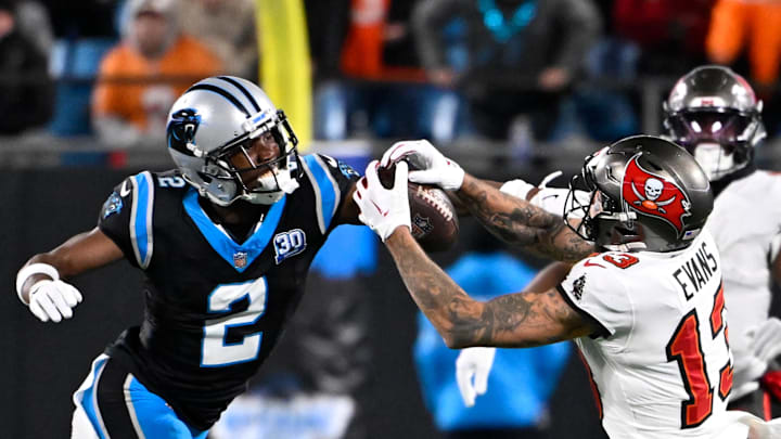 Dec 1, 2024; Charlotte, North Carolina, USA;  Tampa Bay Buccaneers wide receiver Mike Evans (13) catches the ball as Carolina Panthers cornerback Michael Jackson (2) defends in overtime at Bank of America Stadium. Mandatory Credit: Bob Donnan-Imagn Images