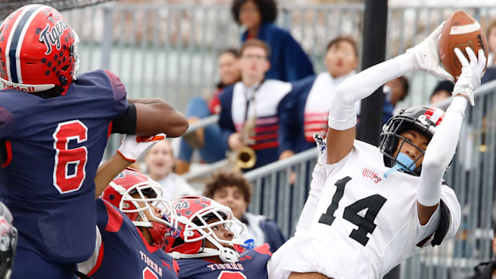 Aliquipp'a Qa'Lil Goode catches a 20-yard touchdown pass on fourth down in front of McKeesport's Javien Robinson (6), Akeen Cochran (2) and Brian Jones (8) with 2 minutes, 5 seconds remaining in the WPIAL Class 4A title game Saturday at Pine-Richland High School. The Quips won their record 21st district crown