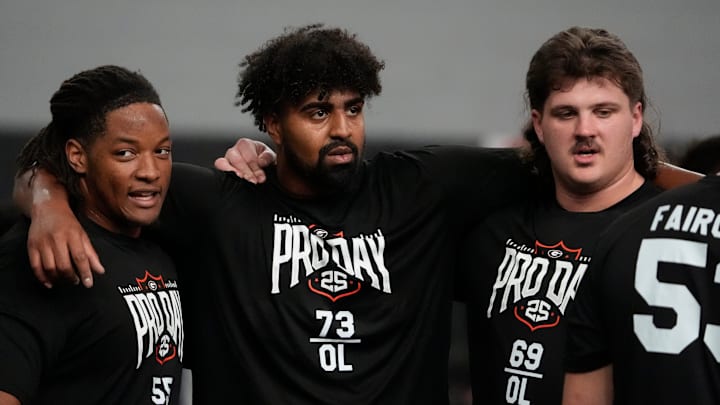 Former Georgia offensive lineman Jared Wilson (55) Xavier Truss (73) and Tate Ratledge (69) huddle up during UGA Footballs Pro Day in Athens, Ga., on Wednesday, March 12, 2025. Representatives from all 32 NFL teams are on hand to watch former UGA football players in action.