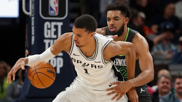 Dec 6, 2023; Minneapolis, Minnesota, USA; Minnesota Timberwolves forward Karl-Anthony Towns (32) defends against San Antonio Spurs forward Victor Wembanyama (1) in the fourth quarter at Target Center. Mandatory Credit: Bruce Kluckhohn-Imagn Images