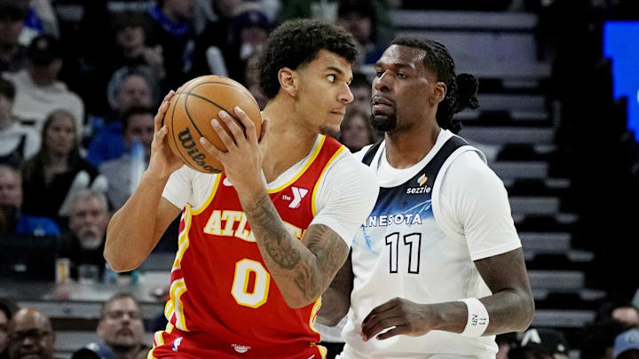 Jan 27, 2025; Minneapolis, Minnesota, USA; Atlanta Hawks forward Dom Barlow (0) posts up as Minnesota Timberwolves center Naz Reid (11) defends him in the third quarter at Target Center. Mandatory Credit: Bruce Kluckhohn-Imagn Images