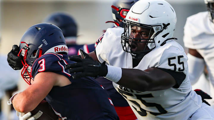 Golden Gate Titans defensive lineman Frederic Sainteus (55) goes to tackle Aubrey Rogers Patriots running back Thomas Pecaro (3) during the first quarter of a spring football game at Aubrey Rogers High School in Naples, Fla., on Wednesday, May 21, 2025.
