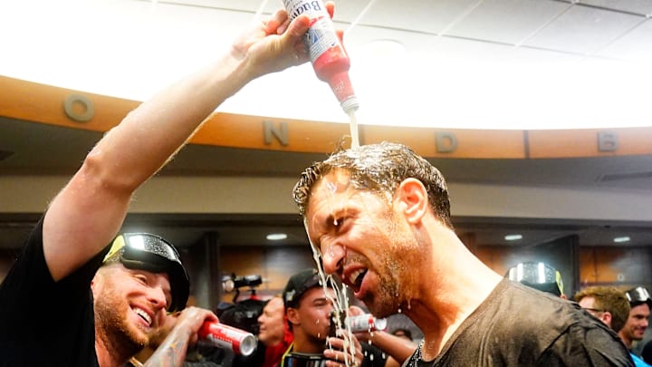 Arizona Diamondbacks starting pitcher Merrill Kelly pours beer over general manager Mike Hazen during celebrations after clinching a wild-card playoff spot following their game with the Houston Astros at Chase Field in Phoenix on Sept. 30, 2023.
