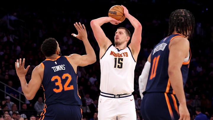 Jan 29, 2025; New York, New York, USA; Denver Nuggets center Nikola Jokic (15) attempts a three point shot against New York Knicks center Karl-Anthony Towns (32) and guard Jalen Brunson (11) during the fourth quarter at Madison Square Garden. Mandatory Credit: Brad Penner-Imagn Images