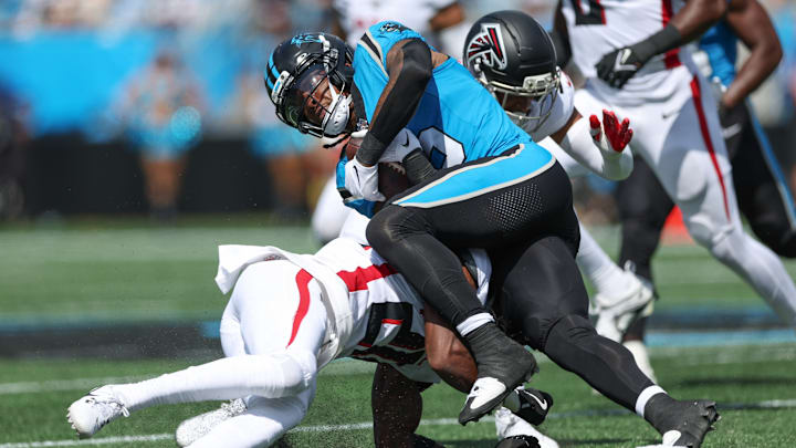 Sep 21, 2025; Charlotte, North Carolina, USA; Carolina Panthers running back Rico Dowdle (5) pushes for yards against Atlanta Falcons cornerback Dee Alford (20) during the first half of a game between Carolina Panthers and the Atlanta Falcons at Bank of America Stadium. 