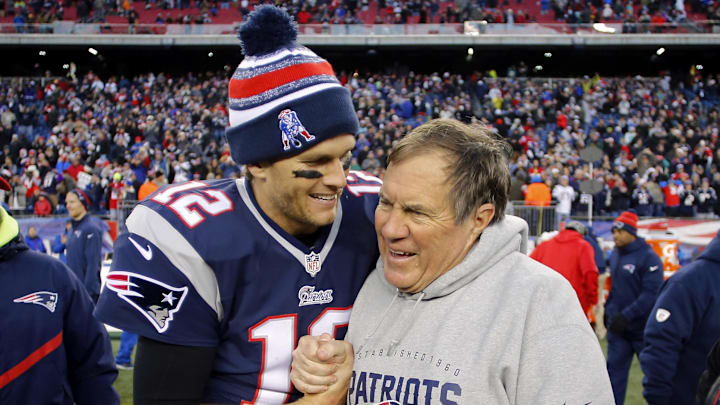 Dec 14, 2014; Foxborough, MA, USA; New England Patriots quarterback Tom Brady (12) celebrates with head coach Bill Belichick (R) after clinching the AFC East title with a 41-13 win over the Miami Dolphins at Gillette Stadium. Mandatory Credit: Winslow Townson-Imagn Images