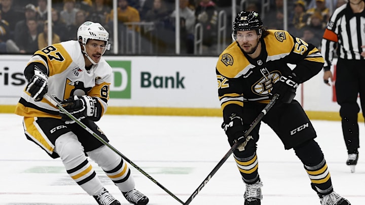 Nov 29, 2024; Boston, Massachusetts, USA; Boston Bruins defenseman Andrew Peeke (52) skates the puck past Pittsburgh Penguins center Sidney Crosby (87) during the first period at TD Garden. Mandatory Credit: Winslow Townson-Imagn Images