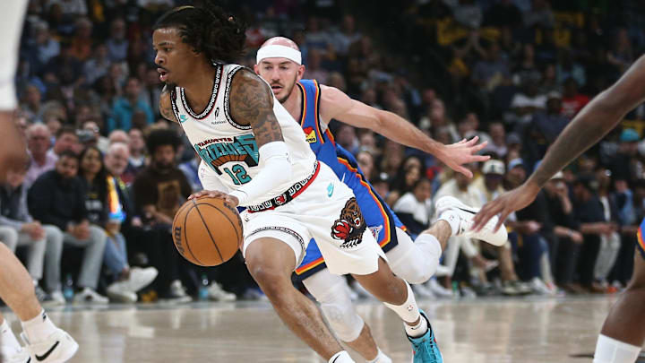 Apr 24, 2025; Memphis, Tennessee, USA; Memphis Grizzlies guard Ja Morant (12) drives to the basket as Oklahoma City Thunder guard Alex Caruso (9) defends during the second quarter during game three for the first round of the 2024 NBA Playoffs at FedExForum. Mandatory Credit: Petre Thomas-Imagn Images Apr 24, 2025; Memphis, Tennessee, USA; Memphis Grizzlies guard Ja Morant (12) drives to the basket as Oklahoma City Thunder guard Alex Caruso (9) defends during the second quarter during game three for the first round of the 2024 NBA Playoffs at FedExForum. Mandatory Credit: Petre Thomas-Imagn Images