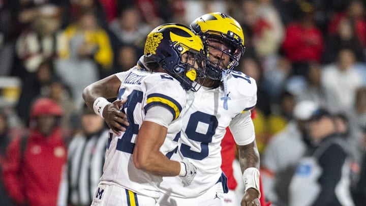 Nov 22, 2025; College Park, Maryland, USA;  Michigan Wolverines quarterback Bryce Underwood (19) celebrates with running back Bryson Kuzdzal (24) after scoring a touchdown during the second half against the Maryland Terrapins at SECU Stadium. Mandatory Credit: Tommy Gilligan-Imagn Images