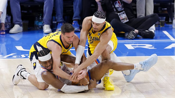 Jun 16, 2025; Oklahoma City, Oklahoma, USA; Oklahoma City Thunder guard Shai Gilgeous-Alexander (2) grabs a loose ball as Indiana Pacers guard T.J. McConnell (9) and guard Andrew Nembhard (2) battle for control during the third quarter in game five of the 2025 NBA Finals at Paycom Center. Mandatory Credit: Alonzo Adams-Imagn Images