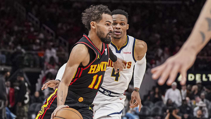 Dec 8, 2024; Atlanta, Georgia, USA; Atlanta Hawks guard Trae Young (11) dribbles past Denver Nuggets guard Russell Westbrook (4) during the second half at State Farm Arena. Mandatory Credit: Dale Zanine-Imagn Images