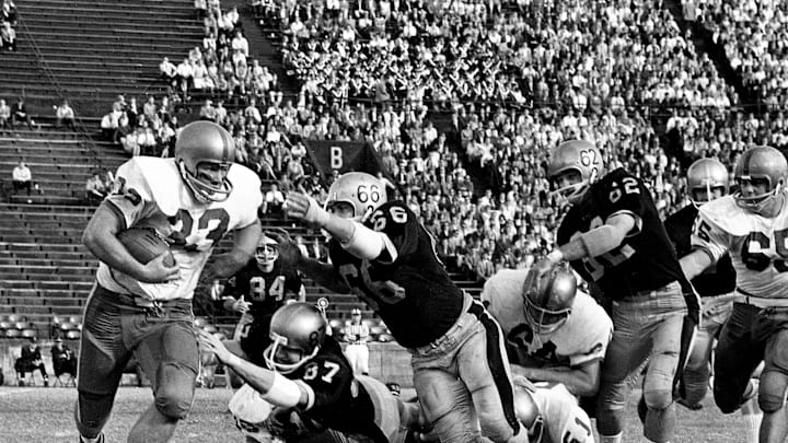 Miami Hurricanes running back Doug McGee (33) is facing two diving Vanderbilt defenders, Steve Skupas (87) and Jimmy Wyatt (66). Rugged Miami defeated the Commodores 28-14 before 12,996 die-hard fans at Dudley Field on Nov. 13, 1965.