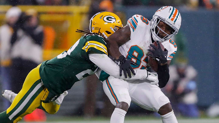 Miami Dolphins wide receiver Malik Washington (83) is wrapped up by Green Bay Packers safety Xavier McKinney (29) after catching a pass on Thursday, November 28, 2024, at Lambeau Field in Green Bay, Wis. The Packers won the game, 30-17.