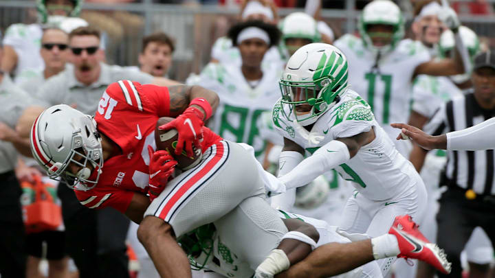 Ohio State Buckeyes wide receiver Emeka Egbuka (12) is tackled by Oregon Ducks safety Verone McKinley III (23) and Oregon Ducks cornerback DJ James (0) on a punt return during Saturday's NCAA Division I football game at Ohio Stadium in Columbus on September 11, 2021.

Osu21ore Bjp 513