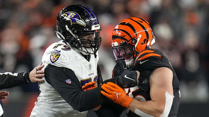 Jan 15, 2023; Cincinnati, Ohio, USA; Baltimore Ravens offensive tackle Ronnie Stanley (79) grips the jersey of Cincinnati Bengals linebacker Logan Wilson (55) after a play in the fourth quarter during an NFL wild-card playoff football game between the Baltimore Ravens and the Cincinnati Bengals at Paycor Stadium. Mandatory Credit: Sam Greene-Imagn Images