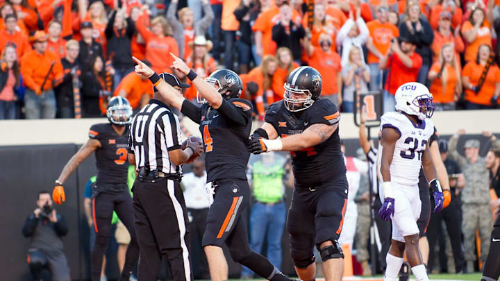 Nov 7, 2015; Stillwater, OK, USA; Oklahoma State Cowboys quarterback J.W. Walsh (4) celebrates a touchdown against the TCU Horned Frogs during the second half at Boone Pickens Stadium. OSU won 49-29. Mandatory Credit: Rob Ferguson-Imagn Images Nov 7, 2015; Stillwater, OK, USA; Oklahoma State Cowboys quarterback J.W. Walsh (4) celebrates a touchdown against the TCU Horned Frogs during the second half at Boone Pickens Stadium. OSU won 49-29. Mandatory Credit: Rob Ferguson-Imagn Images