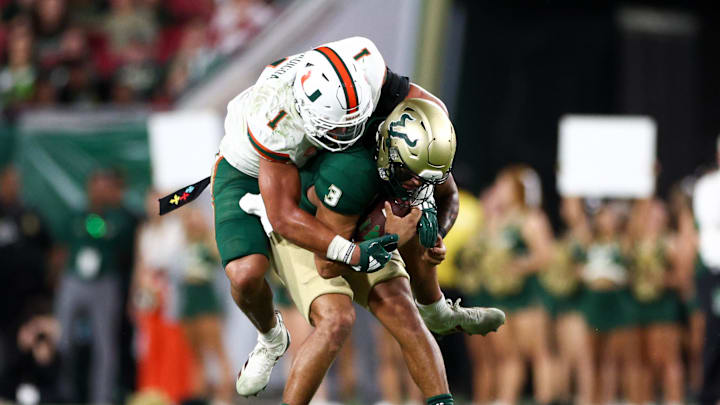 Sep 21, 2024; Tampa, Florida, USA; South Florida Bulls quarterback Bryce Archie (3) is sacked by Miami Hurricanes linebacker Francisco Mauigoa (1) in the fourth quarter at Raymond James Stadium. Mandatory Credit: Nathan Ray Seebeck-Imagn Images
