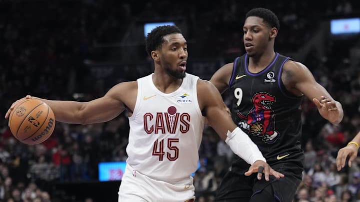 Feb 12, 2025; Toronto, Ontario, CAN; Cleveland Cavaliers guard Donovan Mitchell (45) drives to the net against Toronto Raptors guard RJ Barrett (9) during the second half at Scotiabank Arena. Mandatory Credit: John E. Sokolowski-Imagn Images