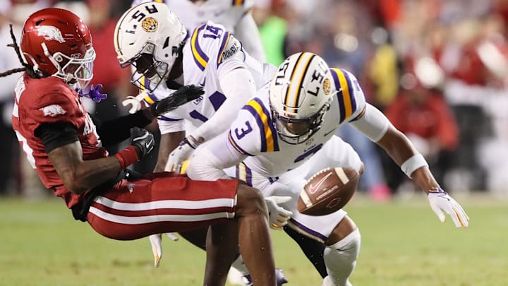 Oct 19, 2024; Fayetteville, Arkansas, USA; Arkansas Razorbacks wide receiver Tyrone Broken (5) attempts a catch as LSU Tigers cornerback Zy Alexander (14) and safety Sage Ryan (3) defend at Donald W. Reynolds Razorback Stadium. Mandatory Credit: Nelson Chenault-Imagn Images