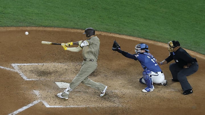 Jul 18, 2025; Washington, District of Columbia, USA; San Diego Padres third baseman Manny Machado (13) hits a grand slam against the Washington Nationals during the ninth inning at Nationals Park. Mandatory Credit: Geoff Burke-Imagn Images