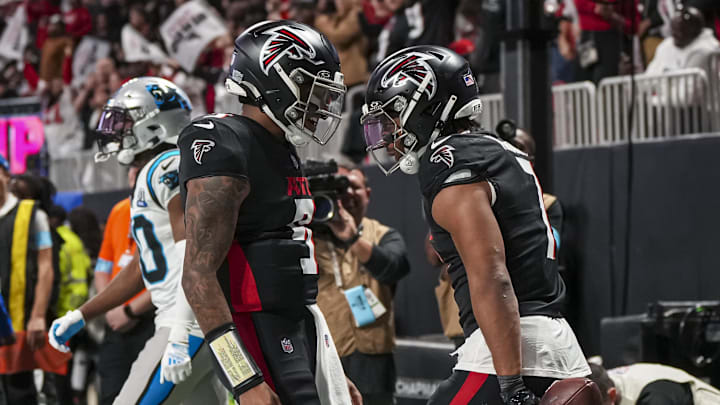 Jan 5, 2025; Atlanta, Georgia, USA; Atlanta Falcons running back Bijan Robinson (7) reacts with quarterback Michael Penix Jr. (9) after running for a touchdown against the Carolina Panthers during the second half at Mercedes-Benz Stadium. Mandatory Credit: Dale Zanine-Imagn Images