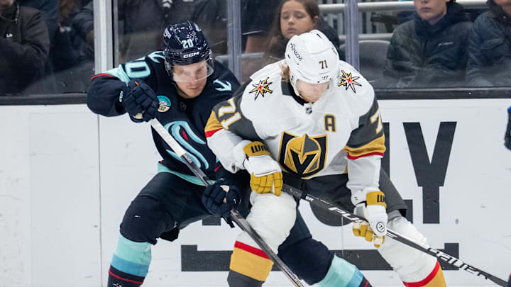 Oct 11, 2025; Seattle, Washington, USA; Seattle Kraken forward Eeli Tolvanen (20) and Vegas Golden Knights forward William Karlsson (71) battle for the puck during the third period at Climate Pledge Arena. Mandatory Credit: Stephen Brashear-Imagn Images