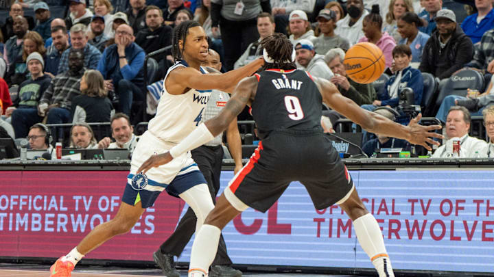 Feb 8, 2025; Minneapolis, Minnesota, USA; Minnesota Timberwolves guard Rob Dillingham (4) passes against Portland Trail Blazers forward Jerami Grant (9) in the third quarter at Target Center. Mandatory Credit: Matt Blewett-Imagn Images
