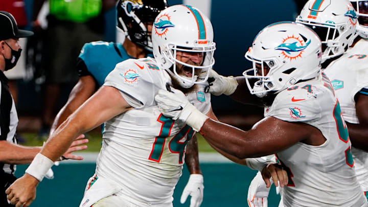 Miami Dolphins quarterback Ryan Fitzpatrick (14) celebrates with defensive tackle Christian Wilkins (94) after scoring a touchdown against the Jacksonville Jaguars during the second half at TIAA Bank Field in a 2020 game.
