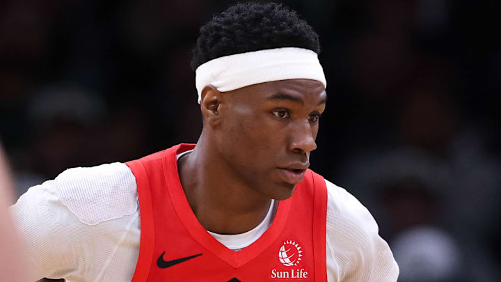 Boston Celtics guard Payton Pritchard dribbles down the court defended by Toronto Raptors guard Ja'Kobe Walter.