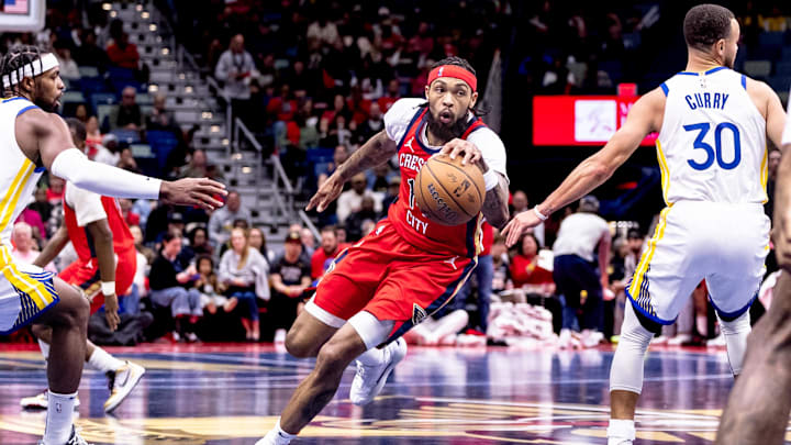 Nov 22, 2024; New Orleans, Louisiana, USA;  New Orleans Pelicans forward Brandon Ingram (14) dribbles against Golden State Warriors guard Stephen Curry (30) and guard Buddy Hield (7) during first half at Smoothie King Center. Mandatory Credit: Stephen Lew-Imagn Images