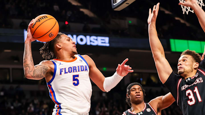 Jan 22, 2025; Columbia, South Carolina, USA; Florida Gators guard Will Richard (5) passes around South Carolina Gamecocks forward Benjamin Bosmans-Verdonk (31) in the second half at Colonial Life Arena. Mandatory Credit: Jeff Blake-Imagn Images