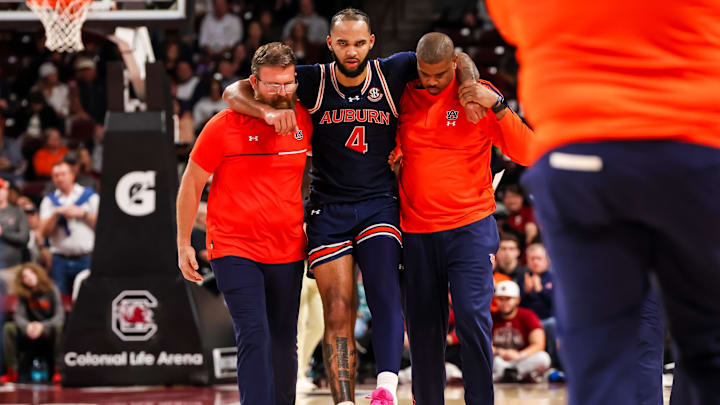 Jan 11, 2025; Columbia, South Carolina, USA; Auburn Tigers forward Johni Broome (4) is helped off the court after sustaining an apparent injury in the second half against the South Carolina Gamecocks at Colonial Life Arena. Mandatory Credit: Jeff Blake-Imagn Images
