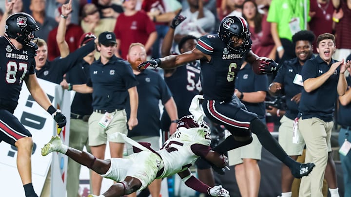 Nov 2, 2024; Columbia, South Carolina, USA; South Carolina Gamecocks tight end Joshua Simon (6) jumps over Texas A&M Aggies defensive back Dalton Brooks (25) while running on a touchdown reception in the second half at Williams-Brice Stadium. Mandatory Credit: Jeff Blake-Imagn Images