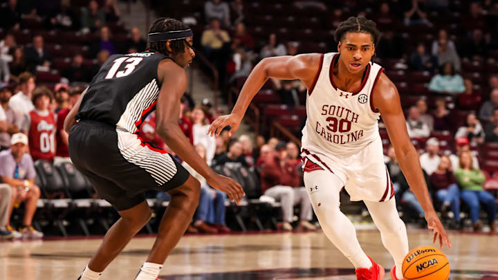 Mar 4, 2025; Columbia, South Carolina, USA; South Carolina Gamecocks forward Collin Murray-Boyles (30) drives around Georgia Bulldogs forward Dylan James (13) in the first half at Colonial Life Arena. Mandatory Credit: Jeff Blake-Imagn Images