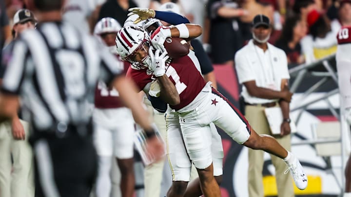 Sep 21, 2024; Columbia, South Carolina, USA;  South Carolina Gamecocks wide receiver Gage Larvadain (7) makes a reception over Akron Zips safety Rodrick Hunter (13) in the second quarter at Williams-Brice Stadium. Mandatory Credit: Jeff Blake-Imagn Images